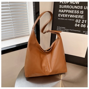 Detailed texture of a brown leather hobo shoulder bag on a metallic table setting