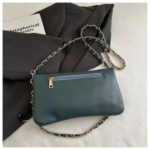Detail of dark green litchi texture shoulder bag with gold chain strap and zip pocket