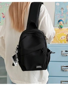 Gros plan sur un sac bandoulière en nylon noir avec étiquette et pendentif chaussure