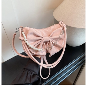 Détail du sac à main rose à nœud avec chaîne en perles et bandoulière fleurie