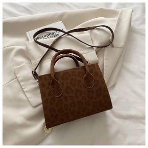 Detailed view of the brown leopard print crossbody bag with handles and gold hardware