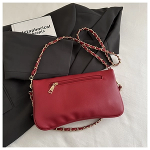 Close-up of red litchi texture leather shoulder bag with gold chain and back zipper pocket
