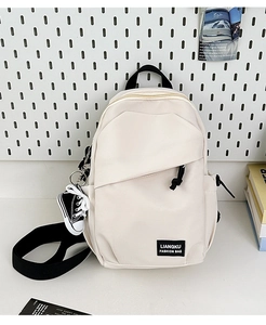 Détail d'un sac à dos blanc en nylon avec porte-clés baskets et étiquette de marque