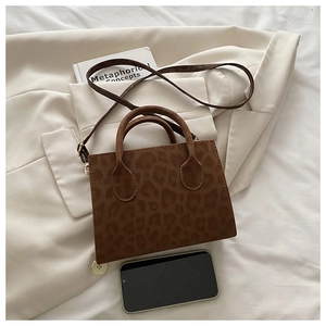 Detail of leopard print tote bag with slim shoulder strap and dual top handles