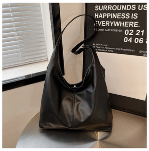 Detail of a minimalist black PU leather hobo bag with sleek shoulder straps and soft folds