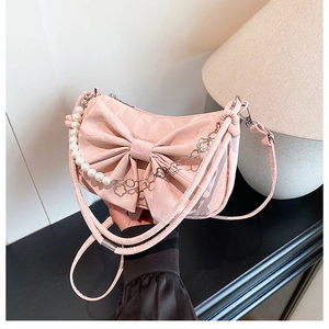 Détail du sac bandoulière en satin rose avec grand nœud et anse en perles chic