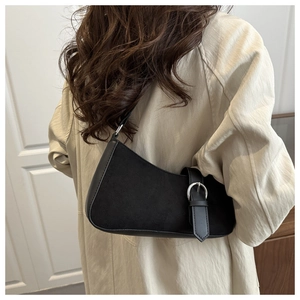 Back view of a model wearing the black suede crescent bag with silver buckle