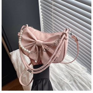 Détail du sac à bandoulière rose plissé avec nœud décoratif et chaîne de perles