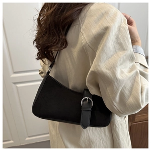 Close-up of black suede crescent bag featuring a silver metal buckle on the shoulder strap