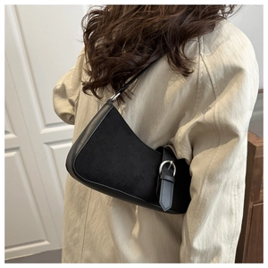Detailed view of black crescent moon bag featuring silver pin buckle and mixed texture