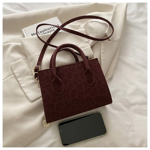 Close-up of leopard print crossbody bag in wine red with a phone for size comparison