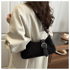 Detail of black crescent shoulder bag with suede finish and large silver buckle hardware