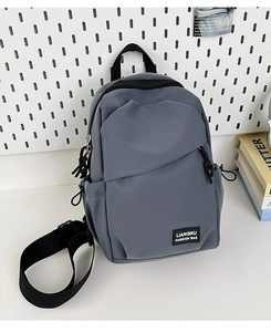 Détail du sac à bandoulière en nylon bleu-gris avec compartiments zippés et poche latérale
