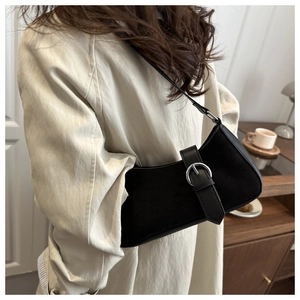 Chic black crescent underarm bag with silver ring buckle shown in a lifestyle street setting