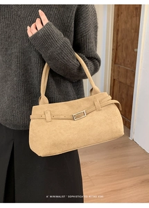 Close-up of matte suede shoulder bag featuring a silver buckle and minimalist strap detail