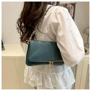Dark green litchi texture shoulder bag with gold chain strap shown on a model