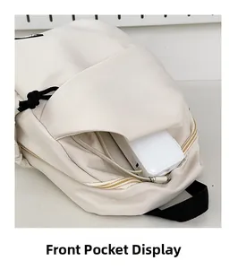 Vista dettagliata della tasca anteriore di una borsa a tracolla beige con spazio interno