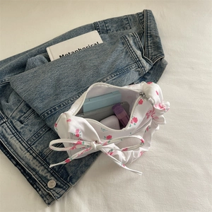 Floral shoulder bag with ruffled handle and bow detail showing interior capacity