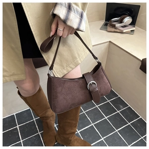 Detail of vintage dark brown suede underarm bag with smooth leather trim and silver buckle