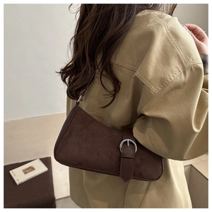 Detail view of a vintage dark brown baguette bag with silver ring buckle and suede texture