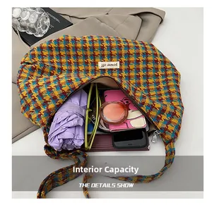 Detailed view of the large capacity interior of this plaid knit dumpling shoulder bag