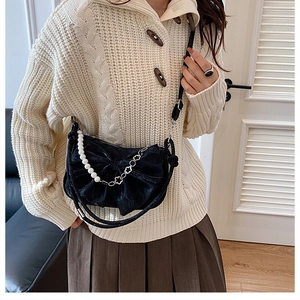 Détail du sac bandoulière noir en velours en forme de nœud avec perles et fleurs