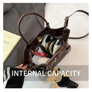 Deep brown leather handbag with large interior capacity and cute plush bear charm