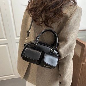 Retro black bowling handbag with front pockets and golden hardware on a model