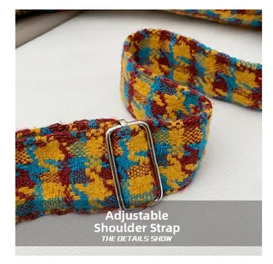 Detail of adjustable woven shoulder strap with colorful houndstooth pattern and silver buckle