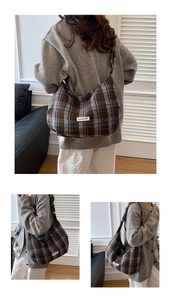 Detail view of large plaid tote bag showing texture and wide shoulder strap