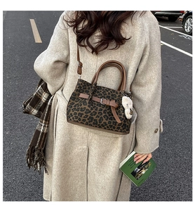 Detail der Bucket-Bag mit Leopardenmuster, braunen Riemen und weißem Plüsch-Anhänger