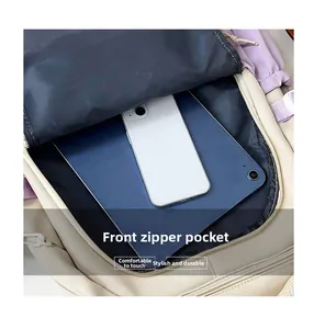 Front zipper pocket of the cream backpack holding a tablet and smartphone for storage