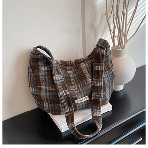 Detail of vintage brown plaid tweed tote bag with metal buckle and power off label