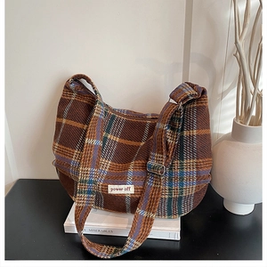 Detail of colorful plaid crossbody bag with power off patch on tweed texture