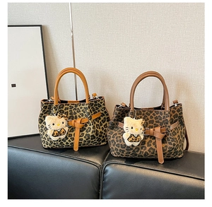 Detailansicht der Tragetasche mit Leopardenmuster und braunen Ledergriffen und Riemen