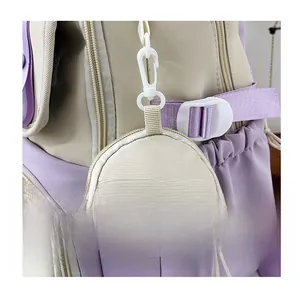 Detail of beige canvas coin purse with white plastic hook attached to a casual backpack