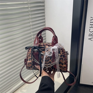 Leopard print shoulder bag with burgundy straps and decorative lace bow details