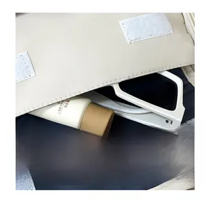 Detail of the front storage pocket on the beige canvas backpack with daily essentials