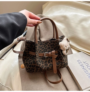 Detail der Handtasche mit Leopardenmuster, Ledergriffen und Plüschbär-Anhänger