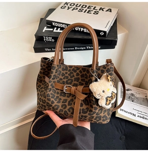 Detailansicht der Bucket Bag mit Leopardenmuster, Ledergriffen und Plüsch-Anhänger
