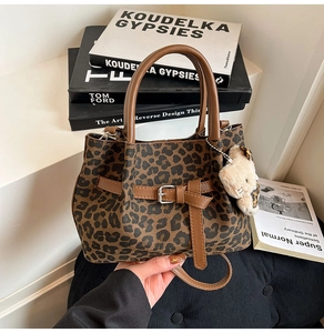 Detailansicht der Beuteltasche mit Leopardenmuster, Ledergriff und süßem Katzenanhänger
