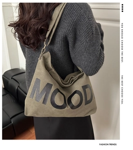 Detail of army green canvas tote bag with black MOOD print and comfortable wide shoulder strap