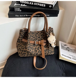 Detail der Leopard-Eimertasche mit Kunstleder-Schnalle und Plüsch-Katzenanhänger