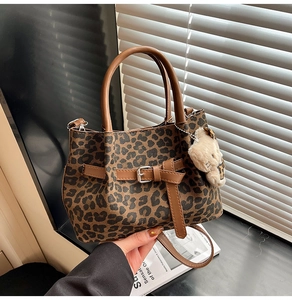 Detail der Handtasche mit Leopardenmuster, Ledergriffen und süßem Plüschbär-Anhänger