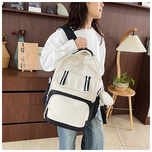 Detail of multi-functional black and white backpack with round coin purse attachment