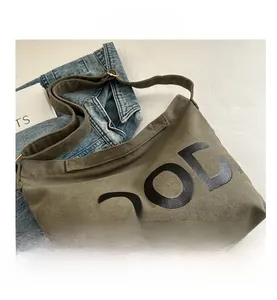 Close-up of army green canvas crossbody bag with MOOD lettering and adjustable strap