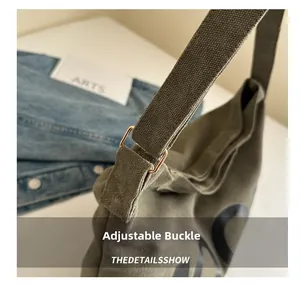 Close-up of military green canvas messenger bag with adjustable metal buckle detail