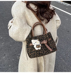 Nahaufnahme der Tote Bag mit Leopardenmuster, Leder Schleife und süßem Plüsch Anhänger