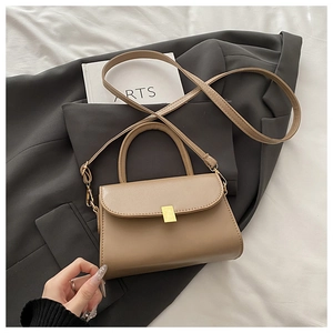 Detail of khaki PU leather square bag with gold buckle on a grey suit and white fabric
