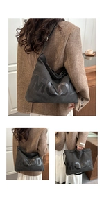 Close-up of black canvas tote bag with MOOD lettering and durable shoulder straps